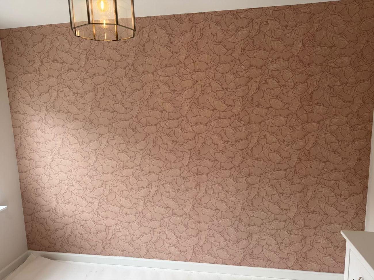 Grafisch bloemenbehang in roze en terracotta tinten