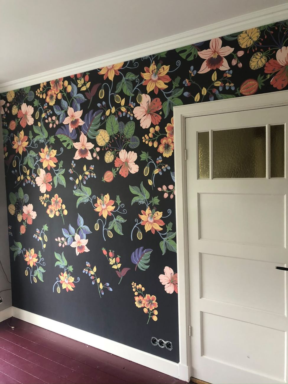 Botanisch bloemenbehang op donkere ondergrond als statement wand