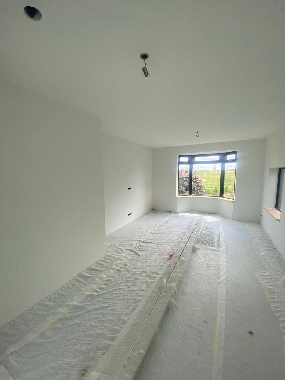 Egaal wit gespoten wanden en plafond in nieuwbouwwoning