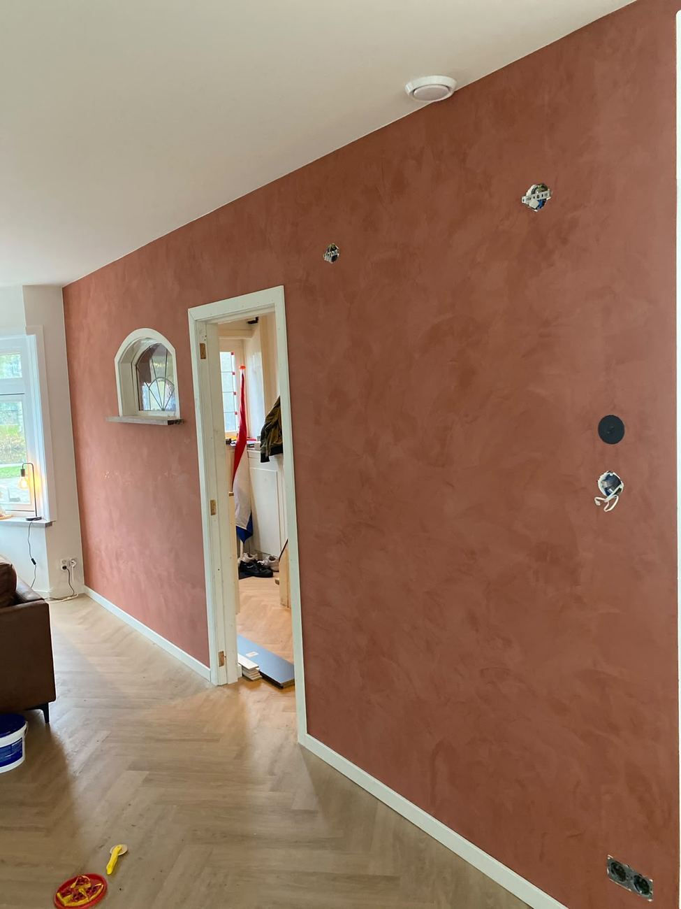 Stucco wandafwerking in een warme terracotta tint