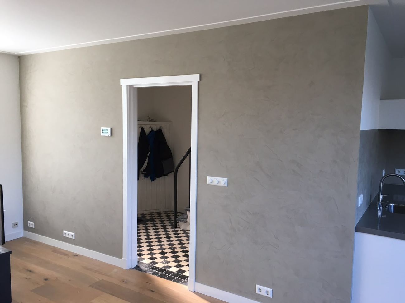 Grijze stucco wandafwerking in een woonkamer
