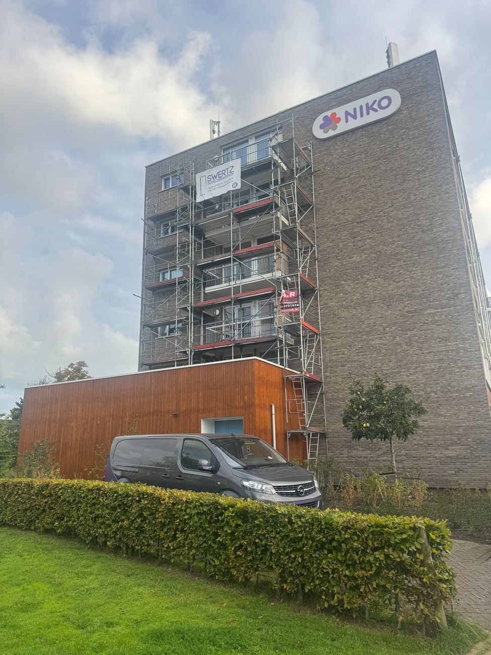 Bedrijfsbus van Swertz Schilderwerken bij een project met steigerwerk