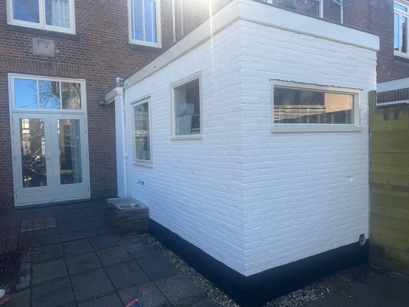 Vers geschilderde witte bakstenen uitbouw na het buitenschilderwerk